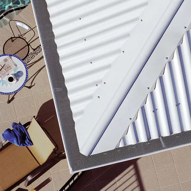 Mesh gutter guard fitted along the gutter of a white corrugated metal roof