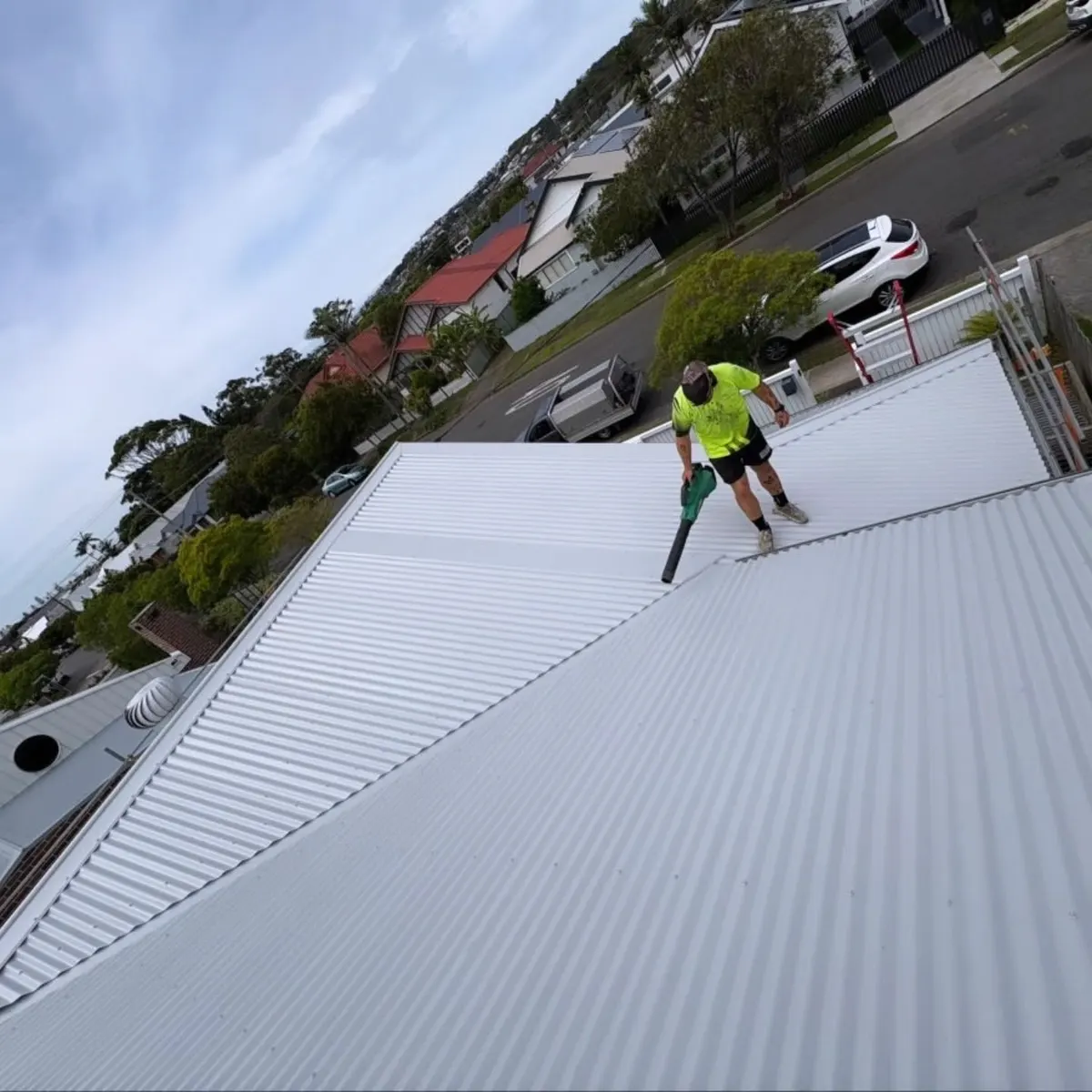 Clearing offcuts from a newly laid white metal roof