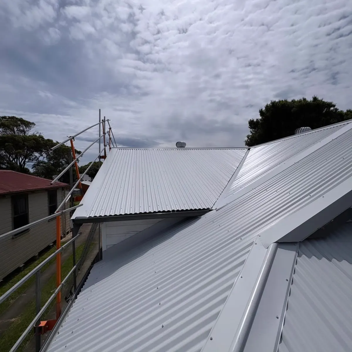 White metal roof complete, with the edge scaffold still up
